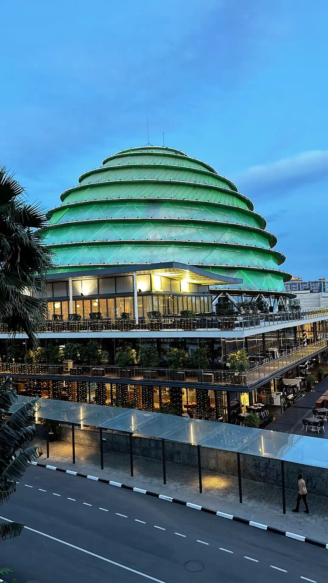 Kigali Convention Centre dome lit green at dusk, Rwanda